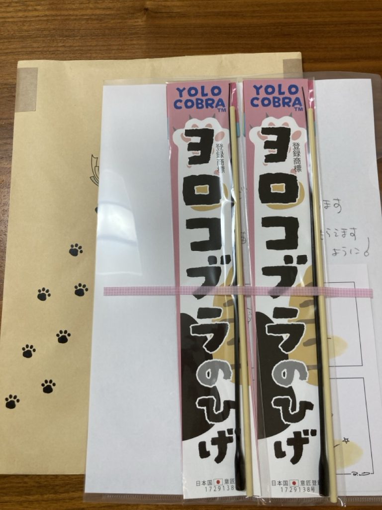 封筒の上に並んだヨロコブラのひげ2本のパッケージ